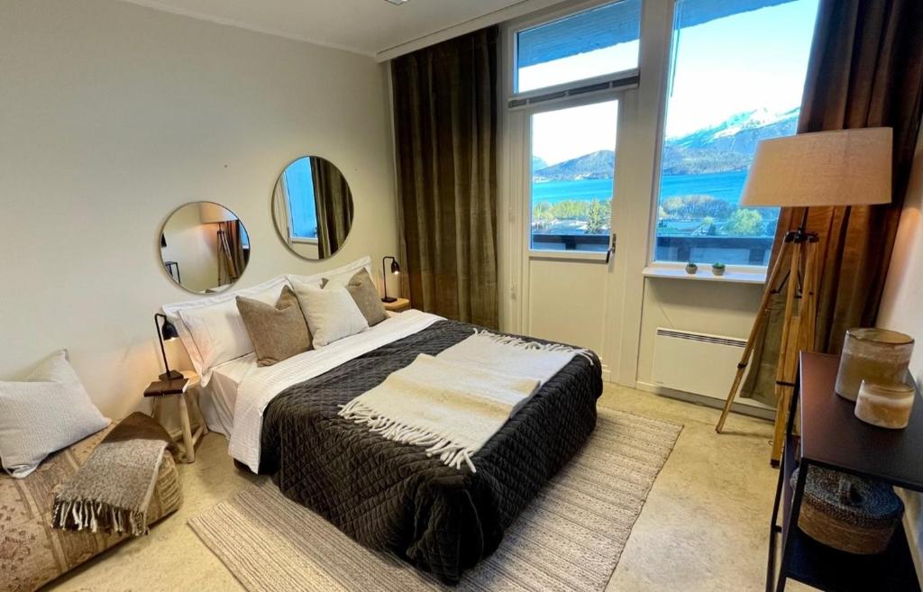 um quarto com uma cama grande e 2 espelhos em A11 em Ålesund