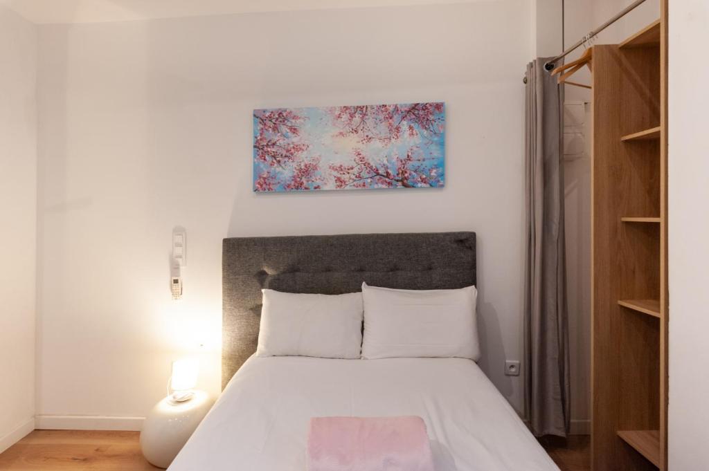 a bedroom with a bed and a painting on the wall at Hotel l'Hotera in Cannes