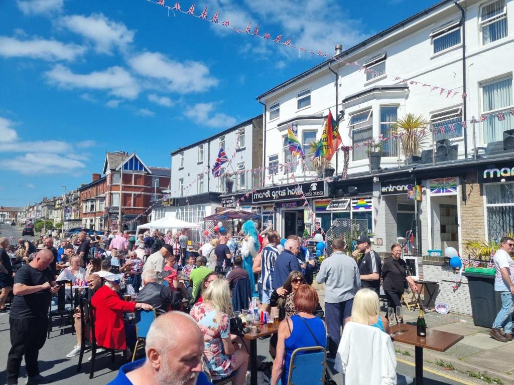 a large crowd of people walking down a street at Mardi Gras Hotel in Blackpool