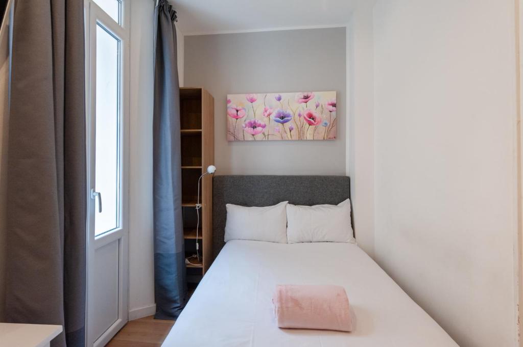 a small bedroom with a bed and a window at Hotel l'Hotera in Cannes