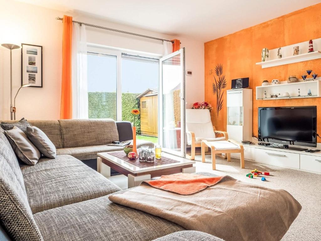 ein Wohnzimmer mit einem Sofa und einem TV in der Unterkunft Am Paalen 26 in Zingst
