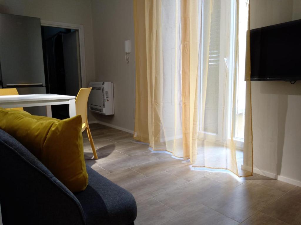 ein Wohnzimmer mit einem Sofa, einem Tisch und einem Fenster in der Unterkunft Paoli 28 Holiday Homes in Corato