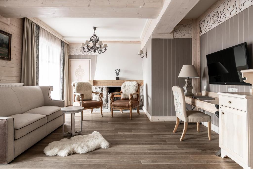 a living room filled with furniture and a tv at Aries Hotel & SPA Zakopane in Zakopane