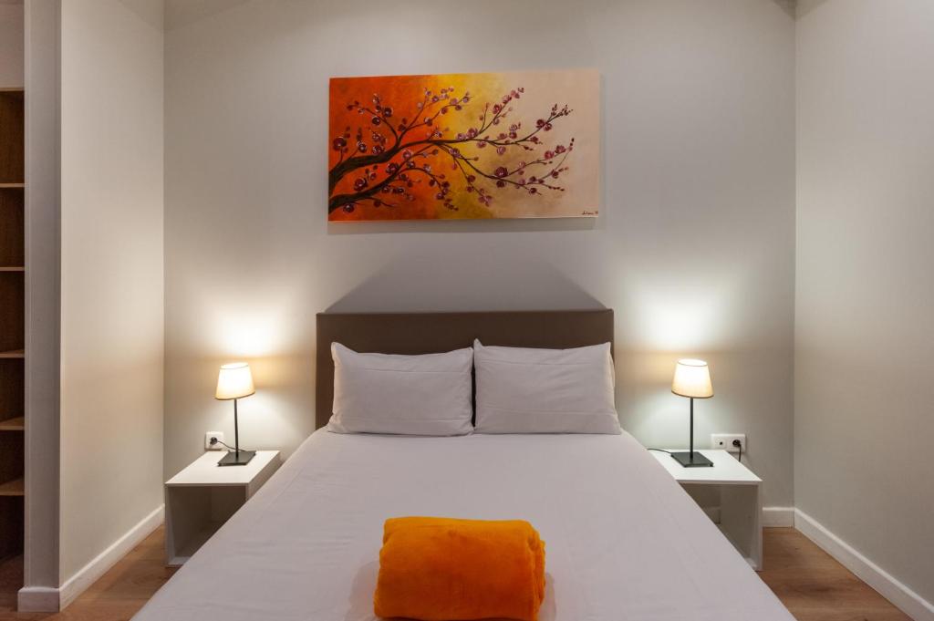 a bedroom with a large bed with two lamps at Hotel l'Hotera in Cannes