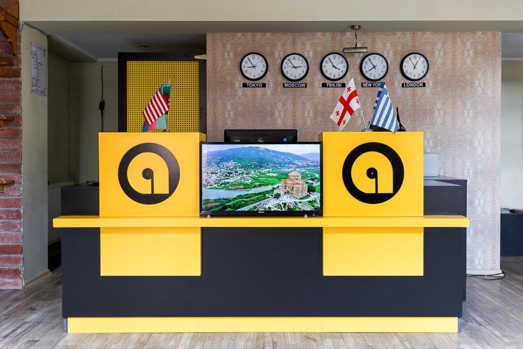 un mostrador amarillo y negro con TV. en Aura Plaza Hotel en Tiflis