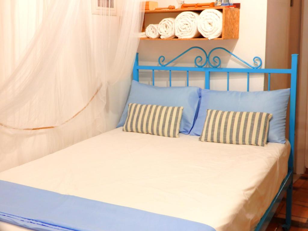 a blue bed with two pillows in a room at Sailor's small studio in Corfu