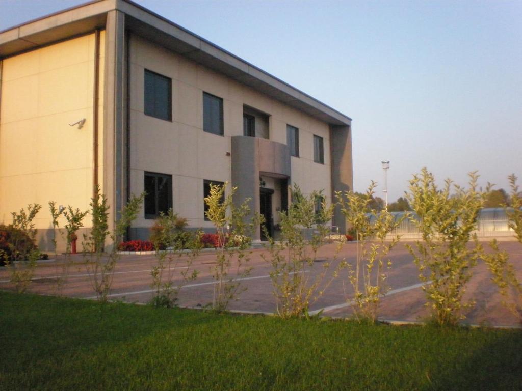a building with a grass field in front of it at Groane Hotel Residence in Cesano Maderno