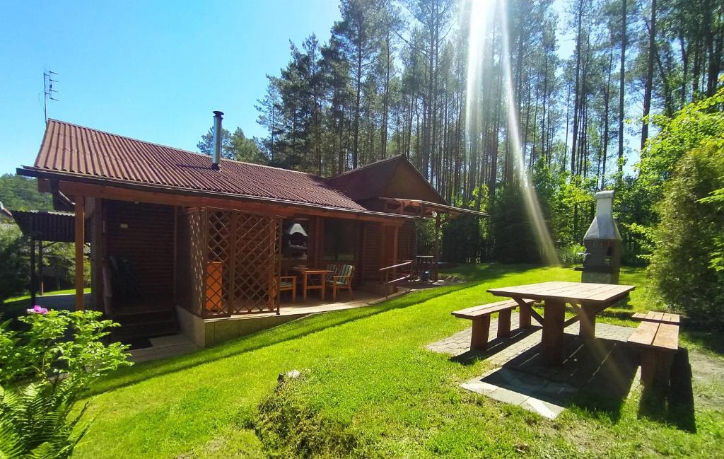 a wooden cabin with a picnic table in the yard at Przylesie Trzebciny in Trzebciny