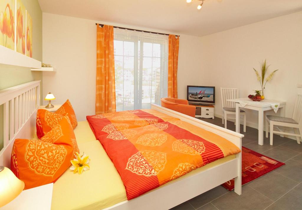 1 dormitorio con 1 cama con almohadas de naranja y naranja en Ferienwohnung Kargoll Wydra in Heringsdorf en Heringsdorf