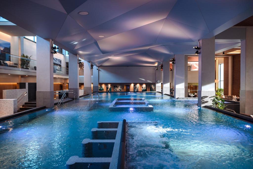 a large swimming pool with blue water in a building at The Well in Kolbotn