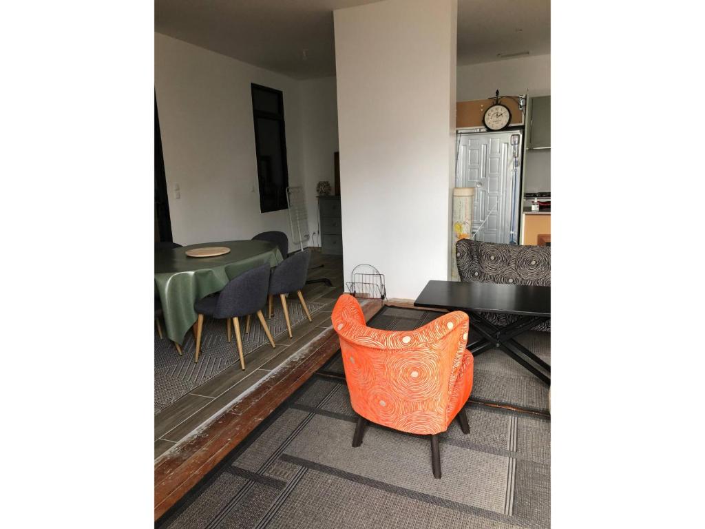 a living room with an orange chair and a table at Rayon de soleil Arcachon in Arcachon