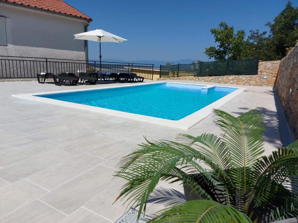 - Piscina con mesa y sombrilla en Kuća za odmor Sara, en Dramalj