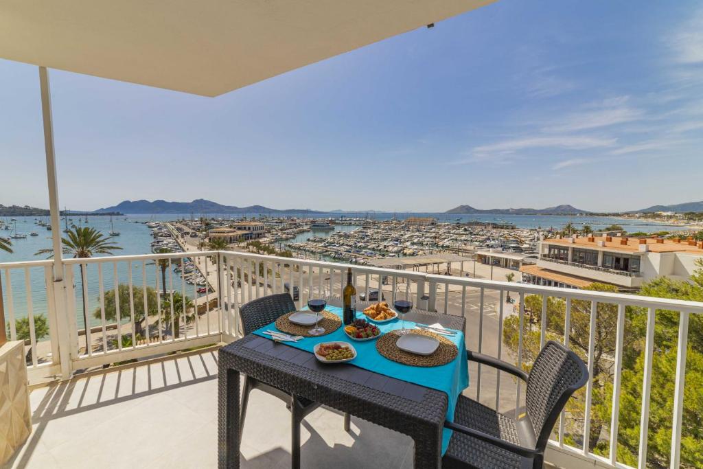a table on a balcony with a view of the water at Apartamento Anamsa in Port de Pollensa