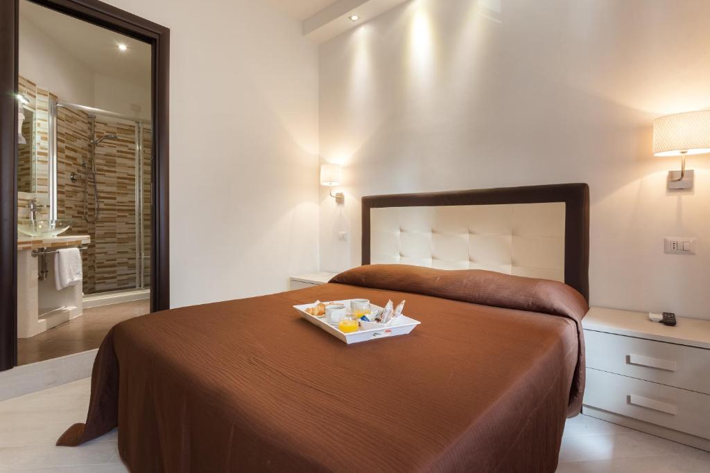 ローマにあるB&B Sol Romaeのベッドルーム1室(ベッド1台、食料品のトレイ付)