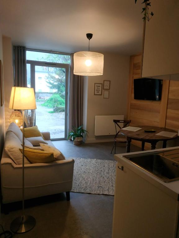 ein Wohnzimmer mit einem Sofa und einem Tisch in der Unterkunft Oxalis in Bagnères-de-Bigorre