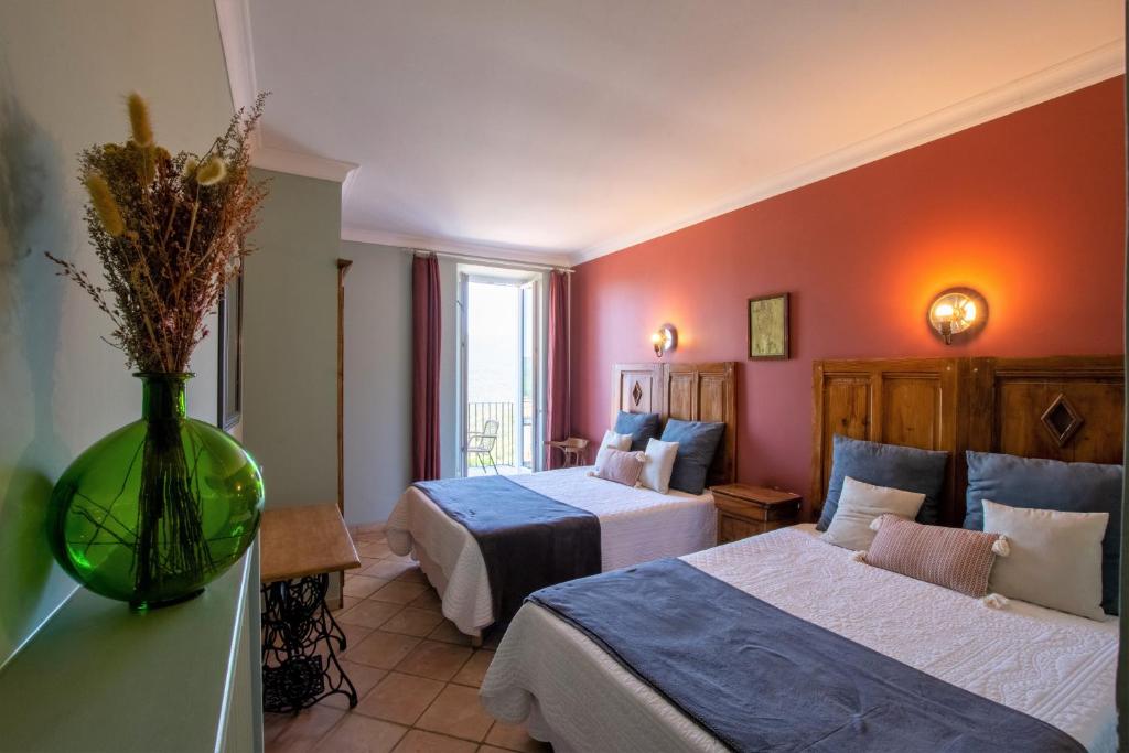 ゾンザにあるHotel La Terrasseのベッド2台と花瓶が備わるホテルルームです。