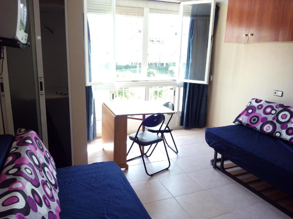 um quarto com uma cama, uma mesa e uma janela em Estudio en La Pineda em La Pineda