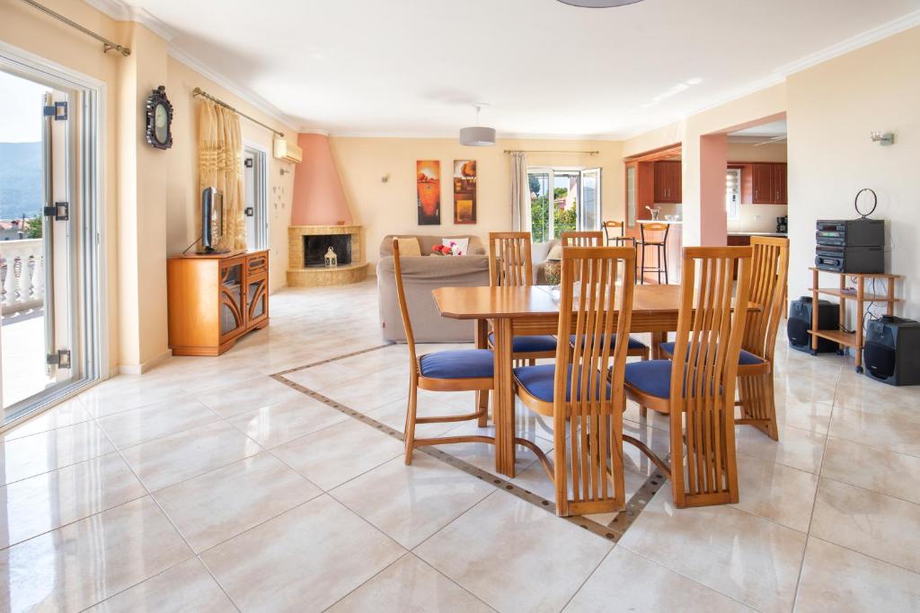 a dining room and living room with a table and chairs at βΙΛΑ ΕΜΜΑΝΟΥΕΛΑ in Sami