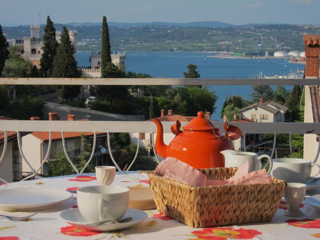 a table with a tea pot and cups on a balcony at Vila Flori in Koper