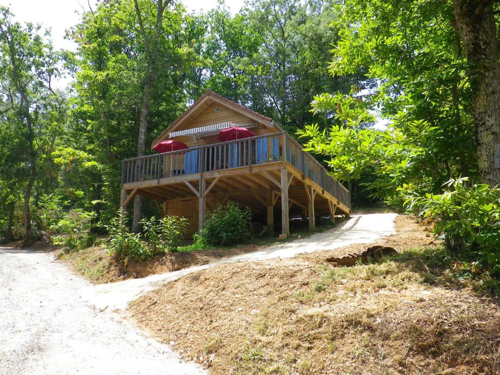 a house with a wrap around deck in the woods at maison sur pilotis in Cazals