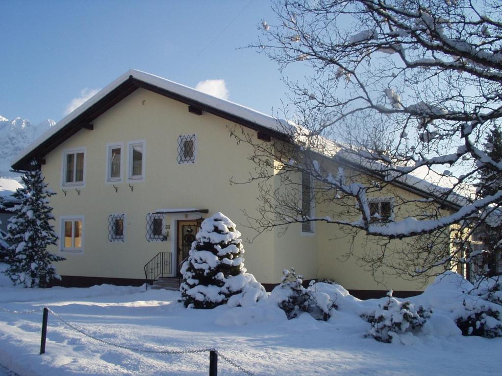 ein weißes Haus mit Schnee auf dem Boden in der Unterkunft Haus Gabriele in Bad Mitterndorf