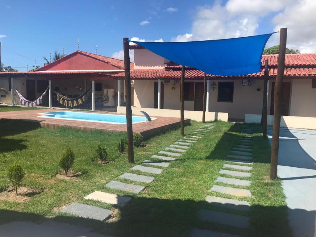 une maison avec une piscine et un toit bleu dans l'établissement Recanto dos Goianos 1 em Prado Bahia, à Prado