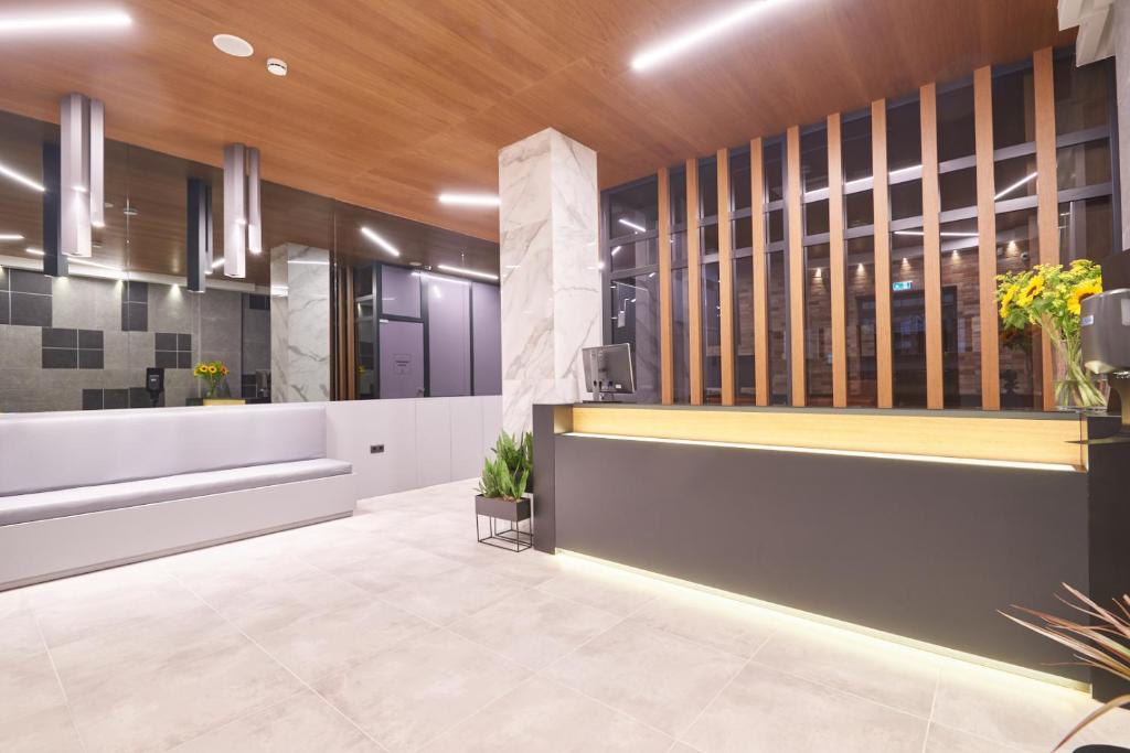 un vestíbulo de oficina con recepción y plantas en The Mavili urban stay en Tesalónica