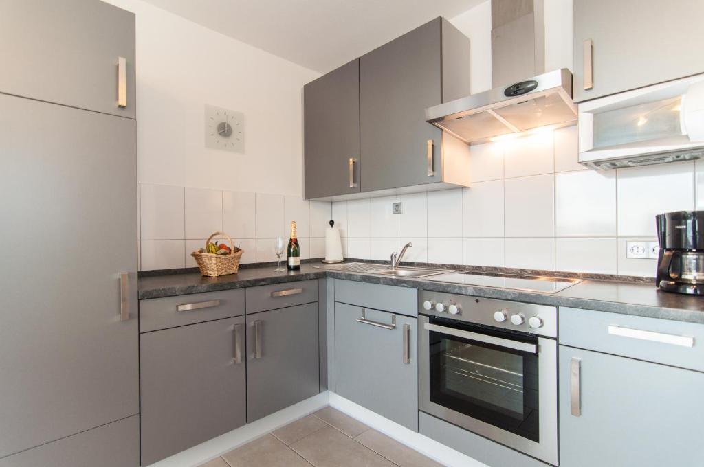 a kitchen with stainless steel appliances and gray cabinets at Monteurwohnung Neuss in Neuss