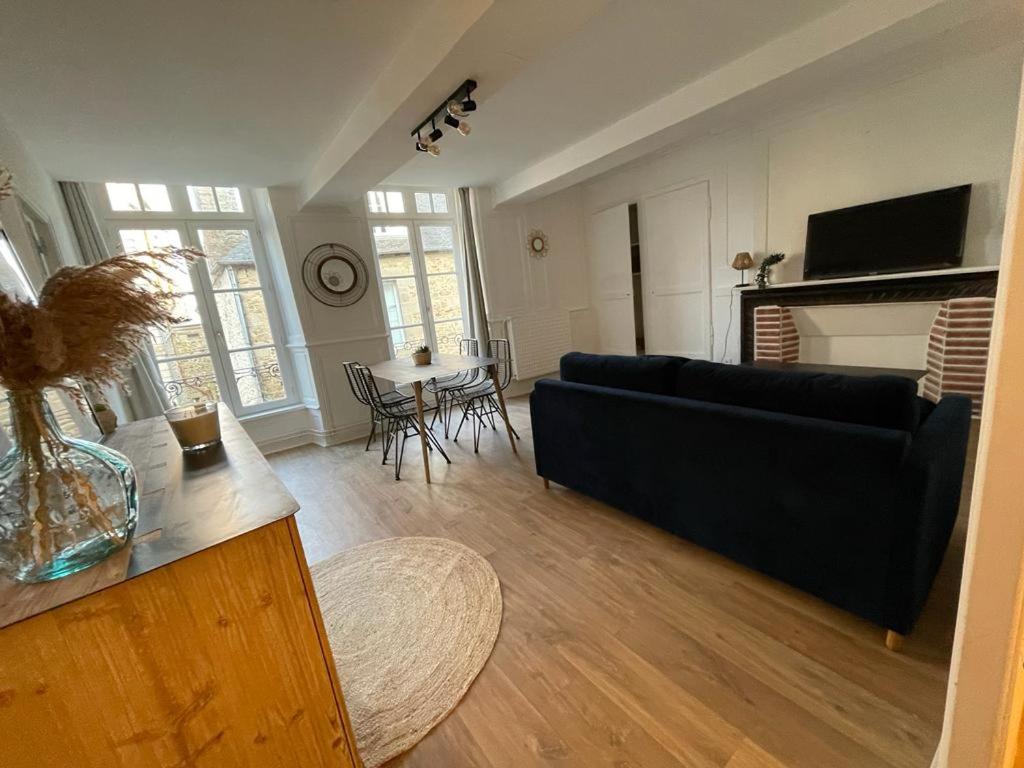 uma sala de estar com um sofá e uma mesa em Le petit Cordelier em Dinan