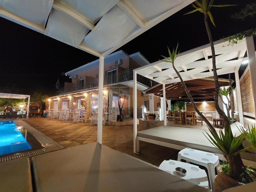 an outdoor patio with a swimming pool at night at Makis louvlis apartments in Moraitika