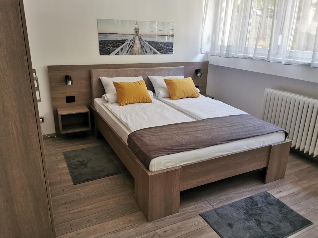 una camera da letto con un grande letto con cuscini gialli di Apartman PAVLOVIC 1 a Dedinje