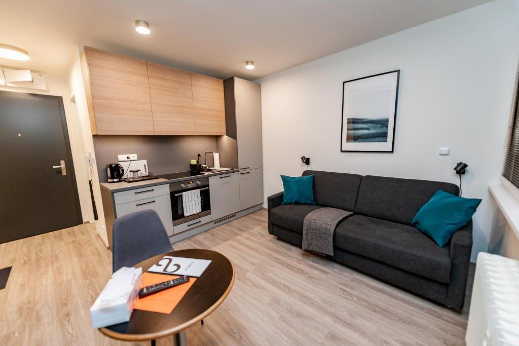 - un salon avec un canapé et une table dans l'établissement Apartments 4u: KAMPUS Upstairs Hradec Králové, à Hradec Králové