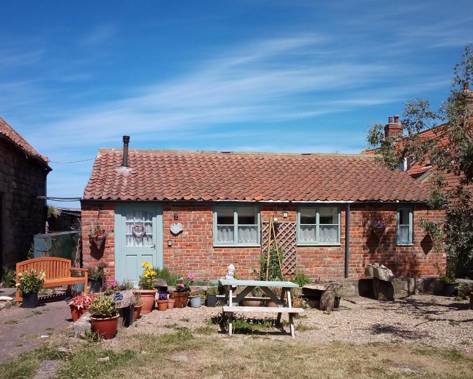 a brick house with a picnic table in front of it at Thyme Cottage in Whitby