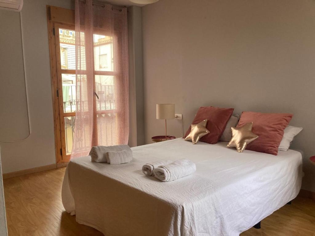 een slaapkamer met een groot wit bed en handdoeken bij La casita de luis in Granada