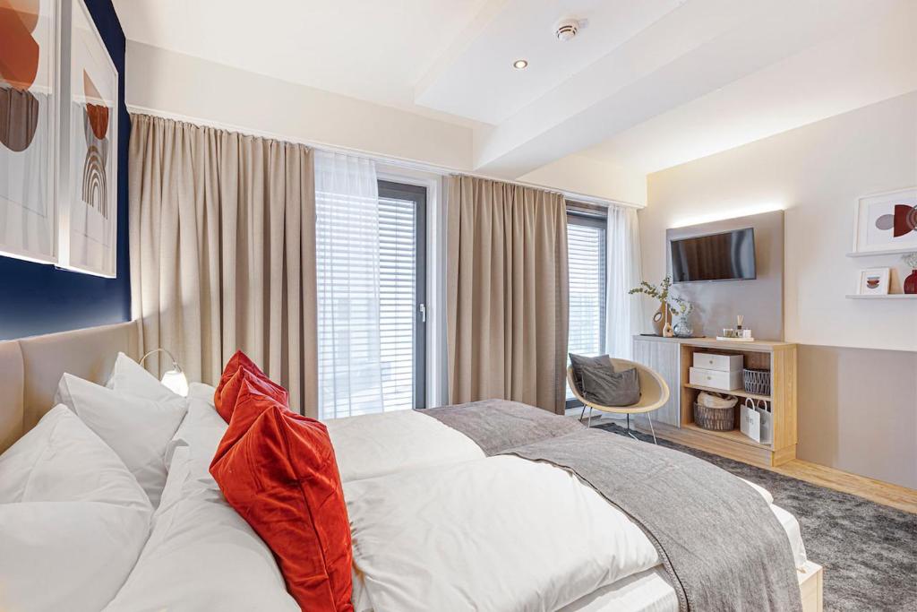 a bedroom with a white bed with a red pillow at Vonder Munich in Munich