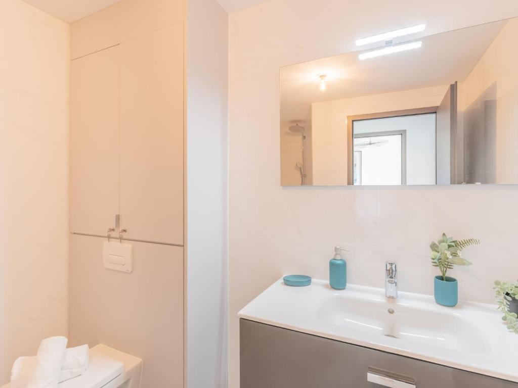 a bathroom with a sink and a mirror at Apartment Stanatura-4 by Interhome in Porto-Vecchio