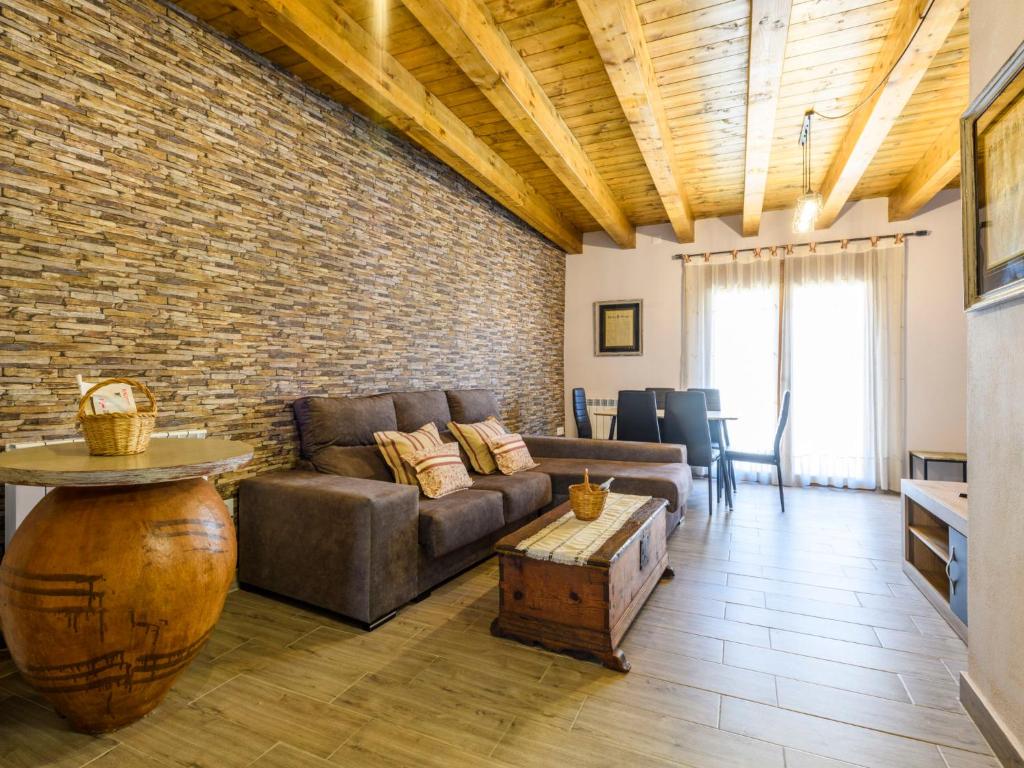 a living room with a couch and a brick wall at Apartment El Ventanico by Interhome in Olocau del Rey