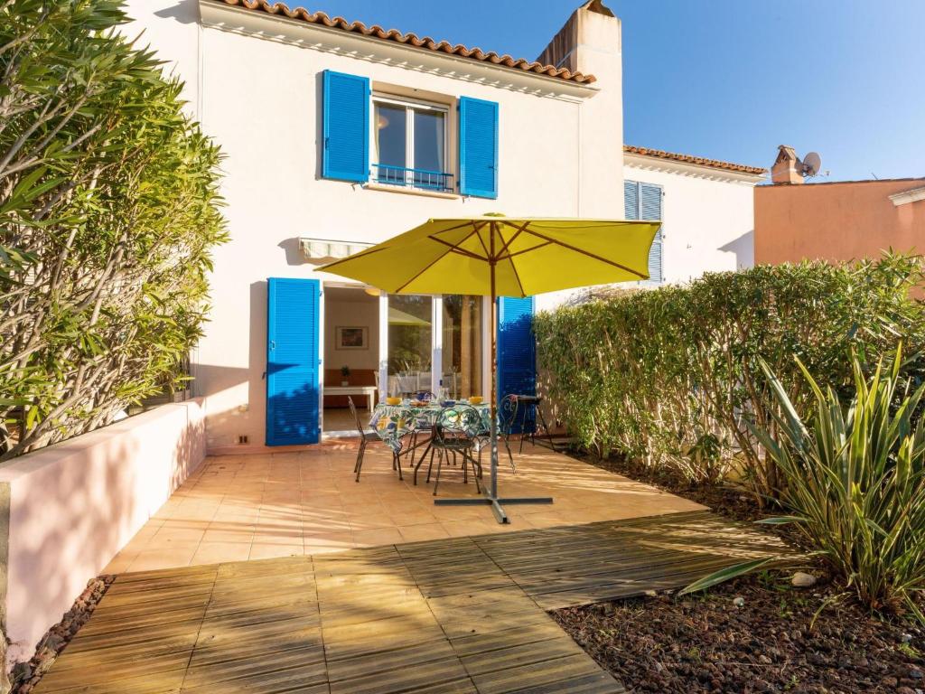 une terrasse avec un parasol jaune et une table dans l'établissement Holiday Home Le Mas d'Esquières 16 by Interhome, aux Issambres