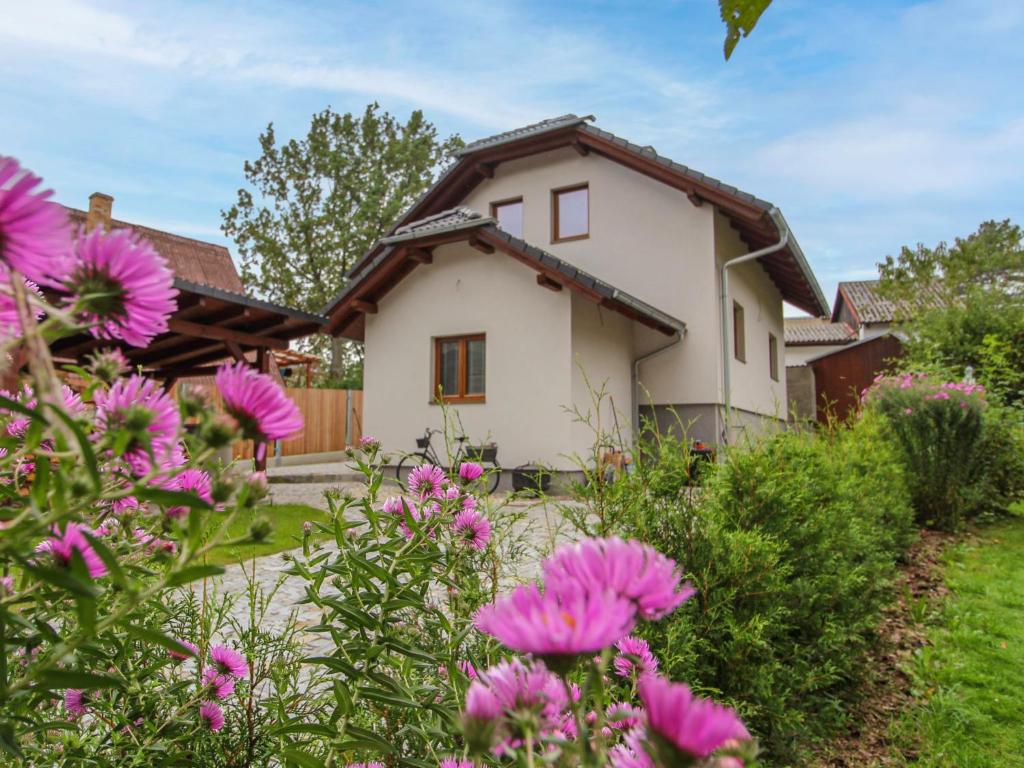 dom z różowymi kwiatami przed nim w obiekcie Holiday Home Dehtáře by Interhome w mieście Hluboká nad Vltavou