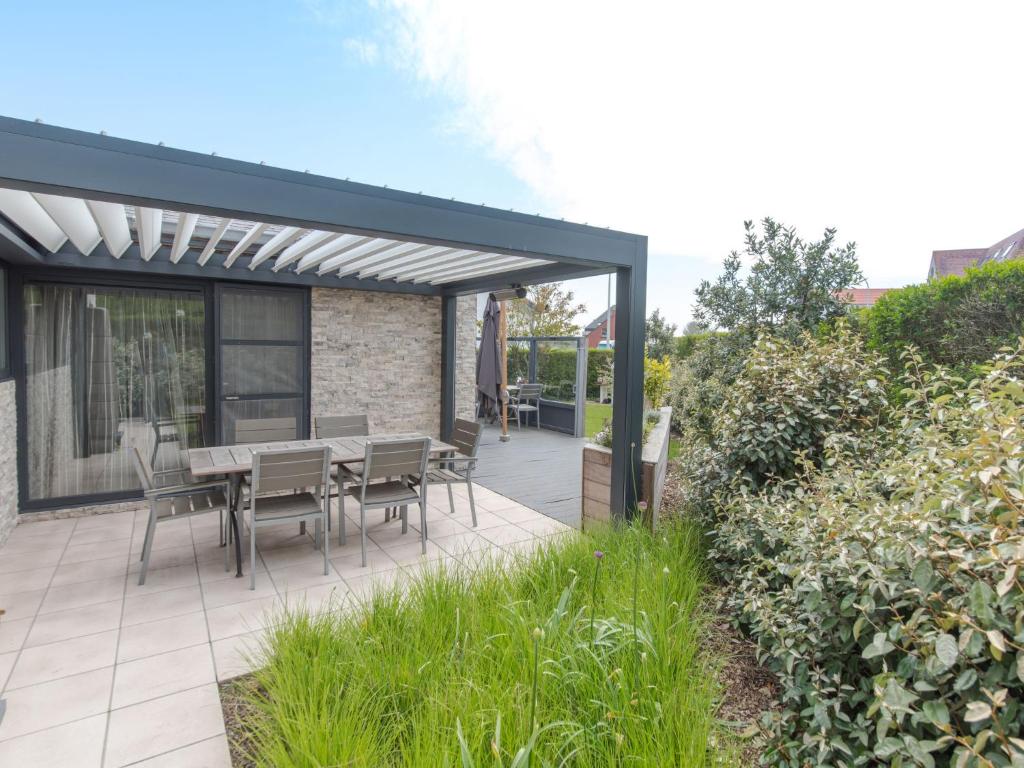a patio with a table and chairs on it at Holiday Home Klemskerkestraat by Interhome in Bredene
