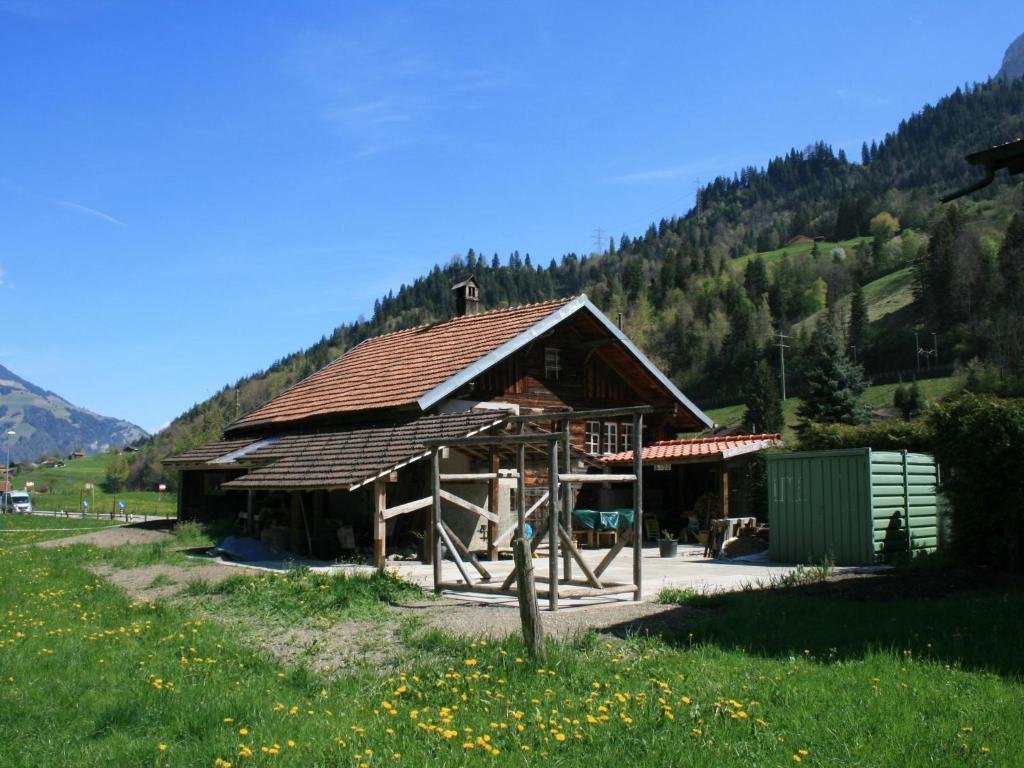 a large wooden building in the middle of a field at Apartment Chalet Bifigen by Interhome in Kandergrund