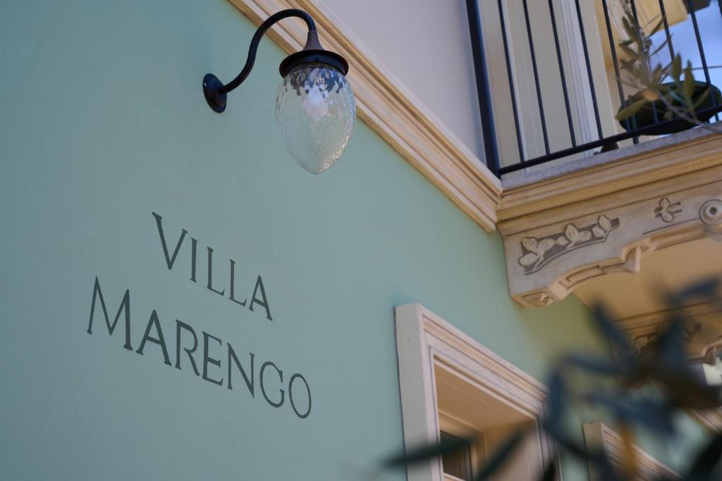 światło wiszące na boku budynku ze znakiem w obiekcie Villa Marengo Guest House w mieście Spinetta