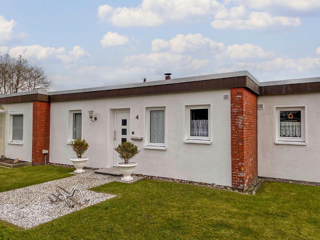 a white house with a grass yard at Holiday Home Siggi by Interhome in Norddeich