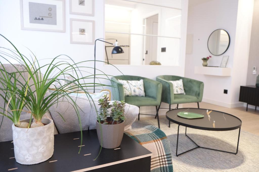 sala de estar con sillas verdes y sofá en Agua Marina, en A Guarda