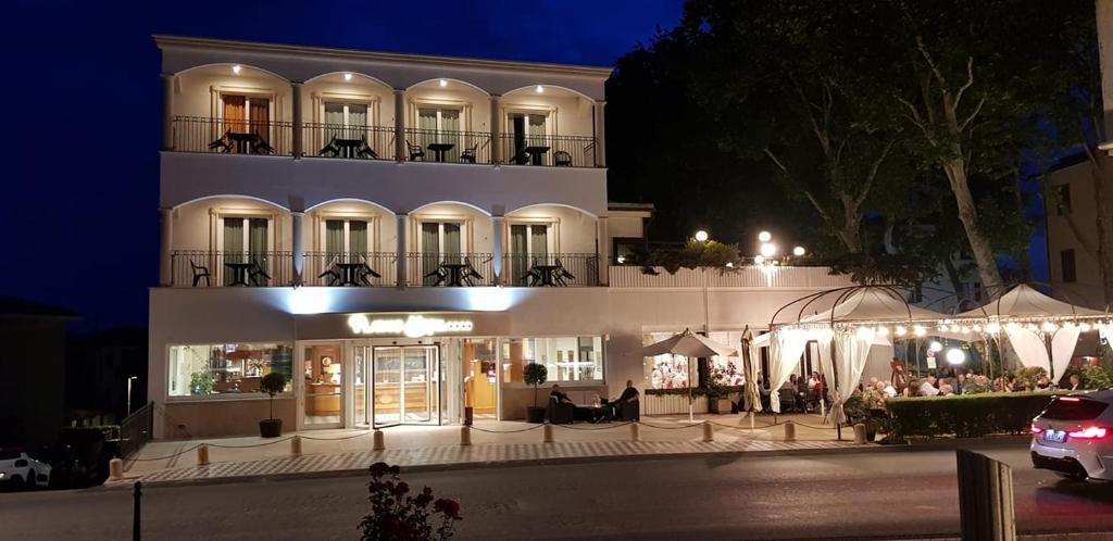 a building with people sitting outside of it at night at Platani Hotel in Bolsena