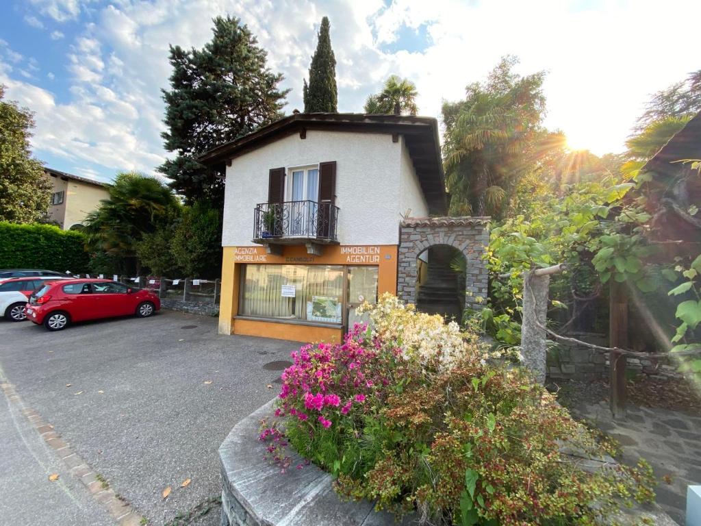 a small house with a balcony and flowers in a parking lot at Holiday Home Casa ai Terreni dei Nonni by Interhome in Losone