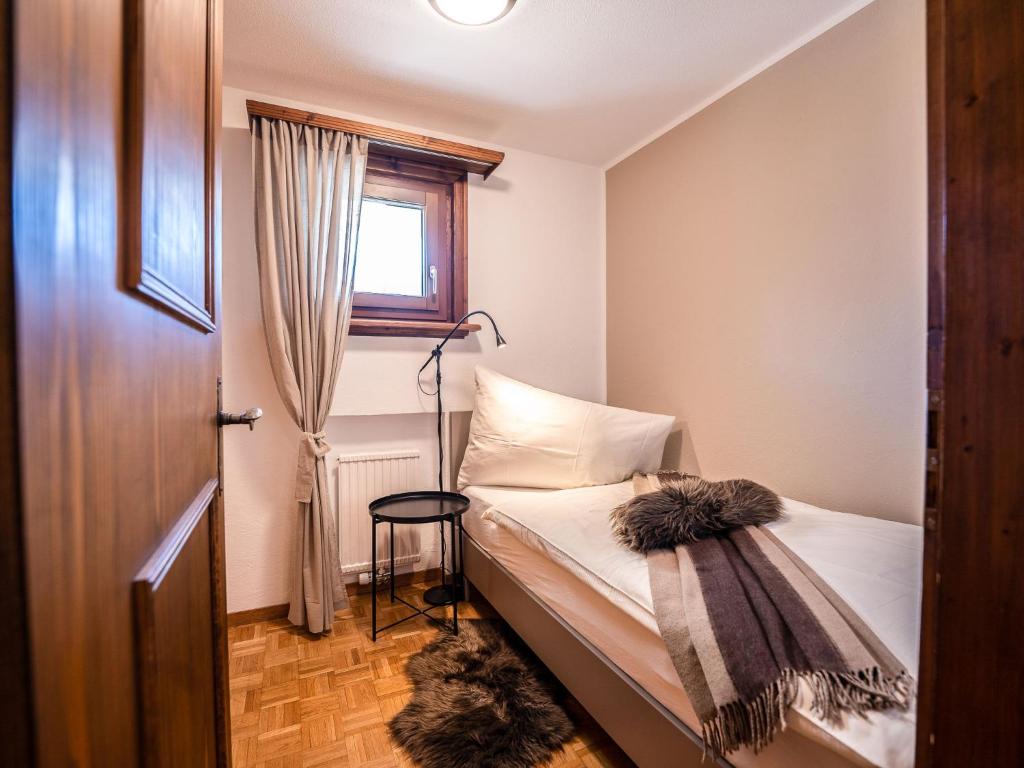a small bedroom with a bed and a window at Apartment Chesa Palüdin 8 - Celerina by Interhome in Celerina