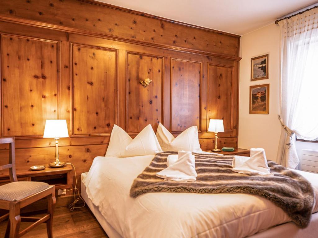 a bedroom with a large bed with a wooden wall at Apartment Chesa Sonnalpine B 48-5 by Interhome in St. Moritz