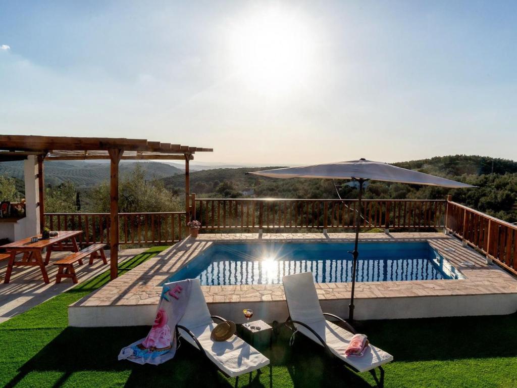una piscina con dos sillas y una sombrilla en Holiday Home La Pedriza by Interhome, en Zambra