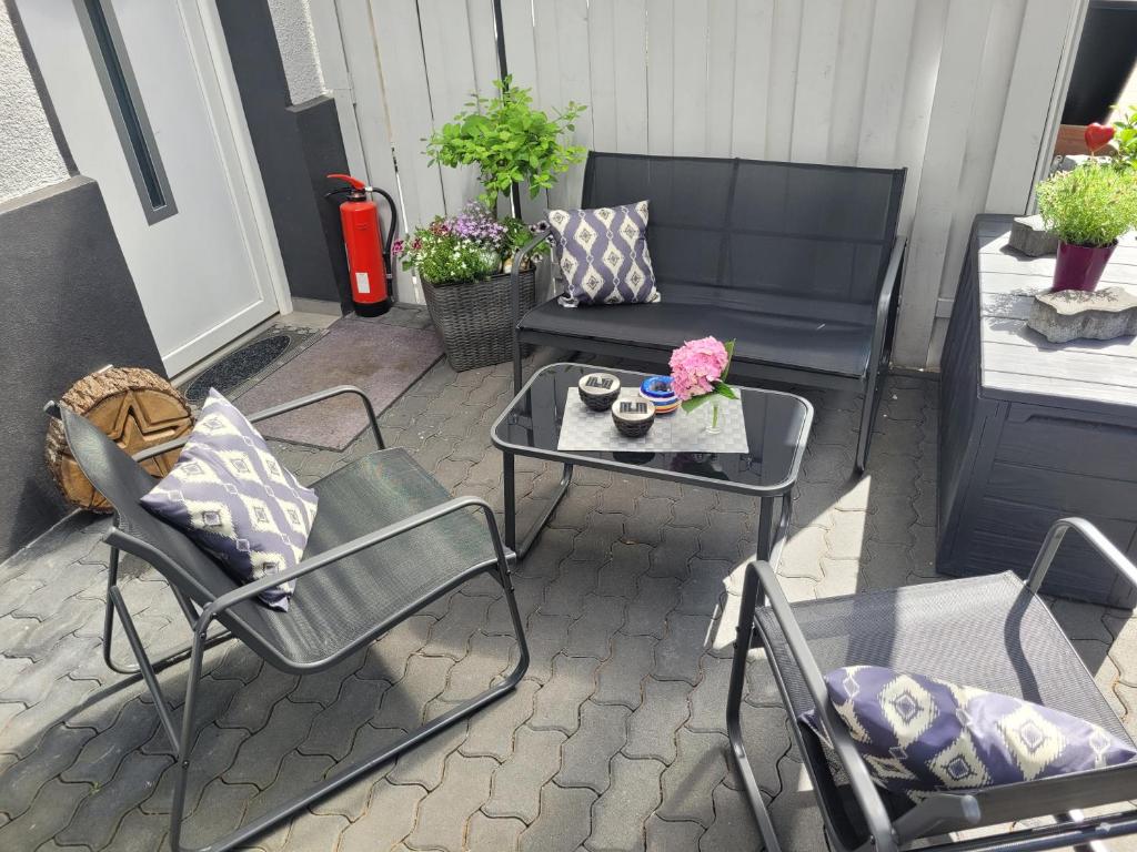 eine Terrasse mit Stühlen, einem Tisch und einem Sofa in der Unterkunft Ferien-, Monteurswohnung in Bottrop in Bottrop